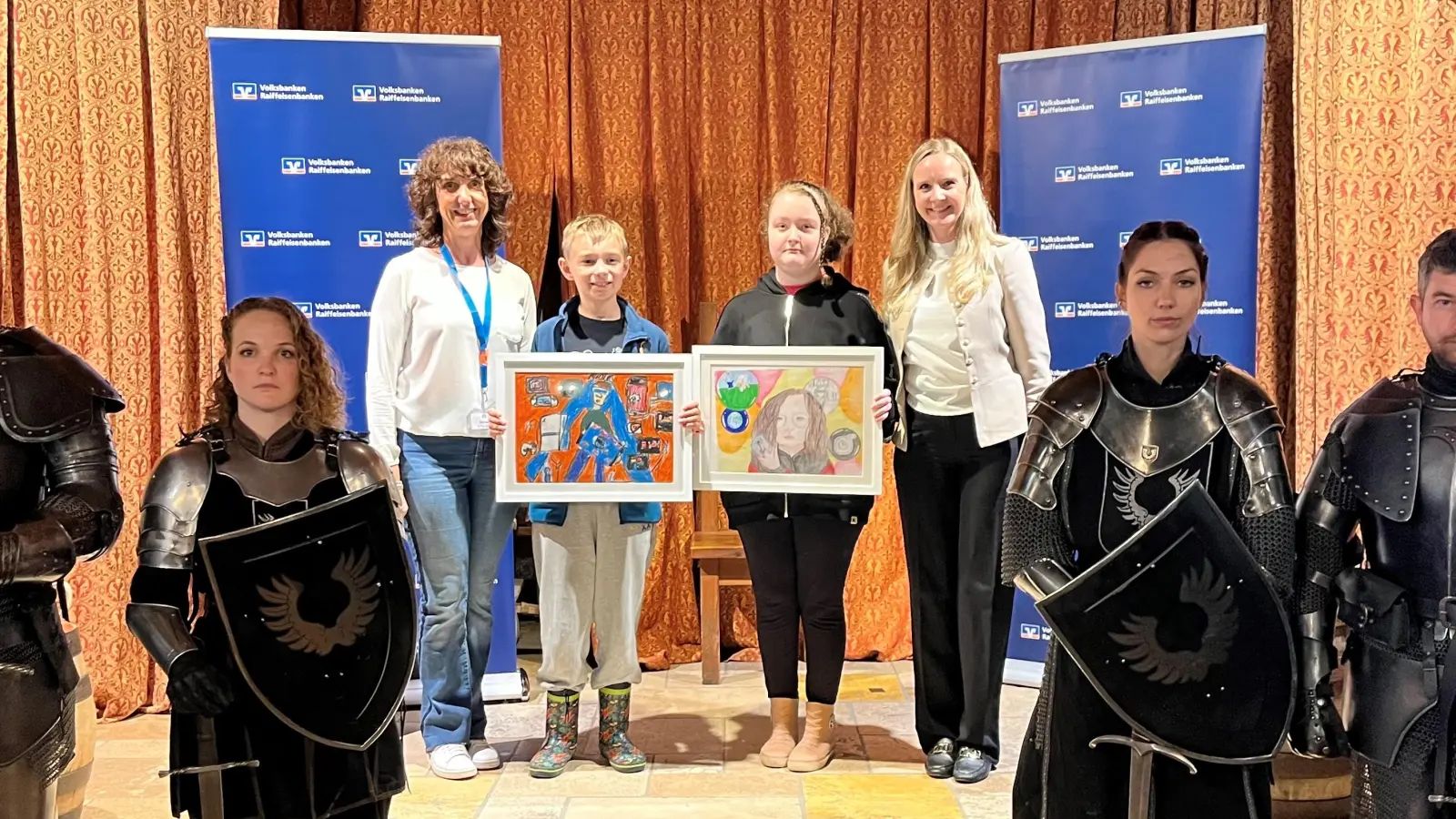 Lev und Amelie bei der Siegerehrung. Links VR-Marketing-Referentin Michaela Steiner. Rechts Marketingleiterin GVB Claudia Köhle-Lösch. (Foto: Genossenschaftsverband Bayern e.V.)