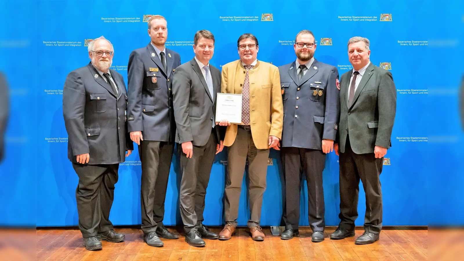 Ehrung mit (von li) Klaus Thalhofer, Kreisbrandinspektor Kasimir Solms-Baruth, Innenstaatssekretär Sandro Kirchner, Maierbräu-Geschäftsführer Christoph Maier, stv. Kommandant Josef Schweighart und der Bayerische Staatsminister für Wohnen, Bau und Verkehr Christian Bernreiter. (Foto: Sebastian Widmann / StMI)